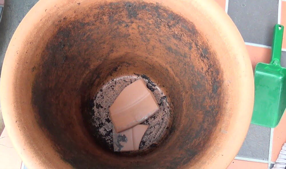 A terracotta pot with crocks in the bottom