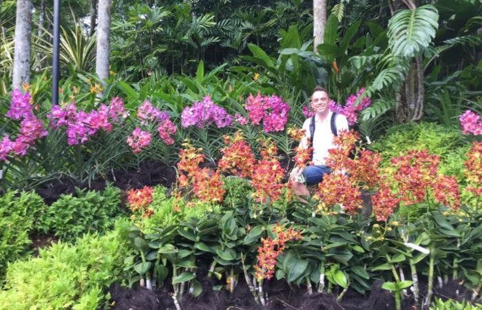 Lee Burkhill sat in a field of Orchids in Singapore
