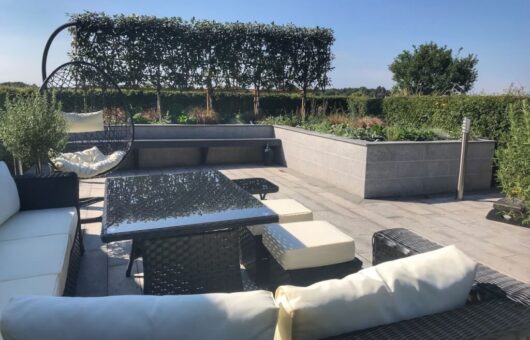 Outdoor living social garden with a white sofa by Garden Ninja