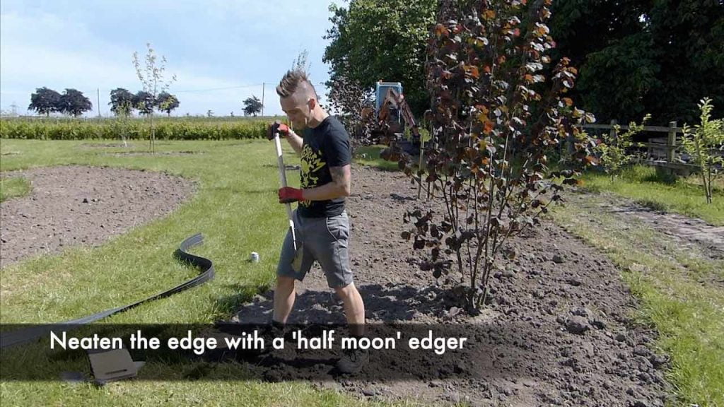 Edging a lawn with a half moon edger tool