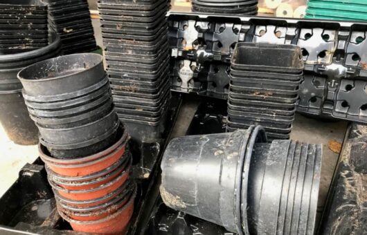A stack of black plastic plant pots