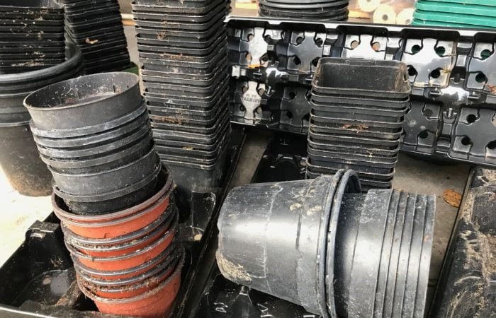 A stack of black plastic plant pots