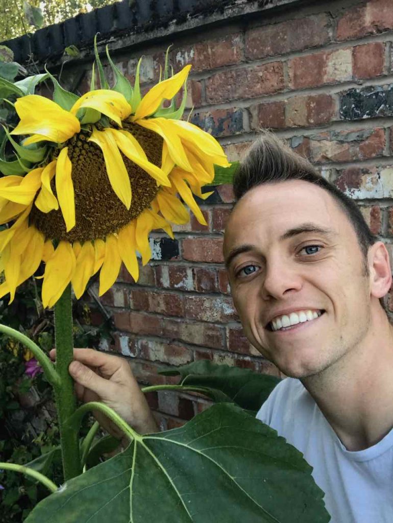 Garden Ninja holding a sunflower