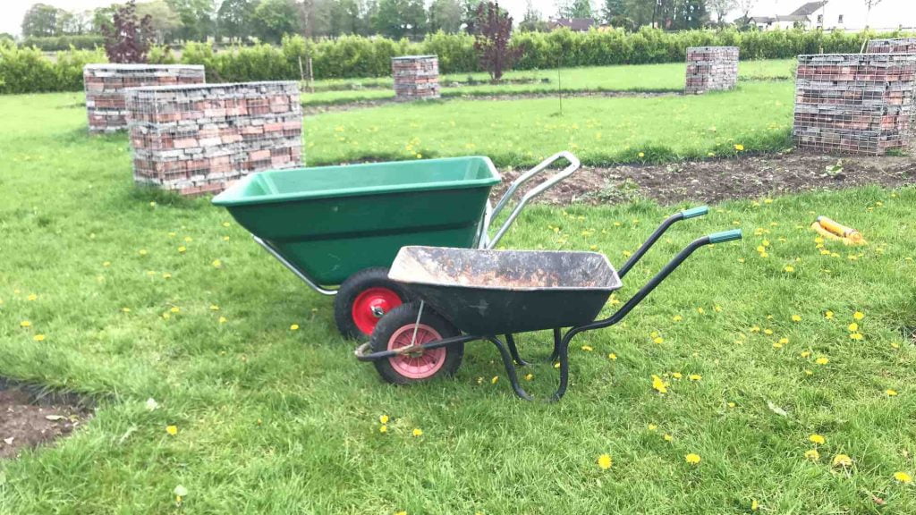 A small and large wheelbarrow side by side