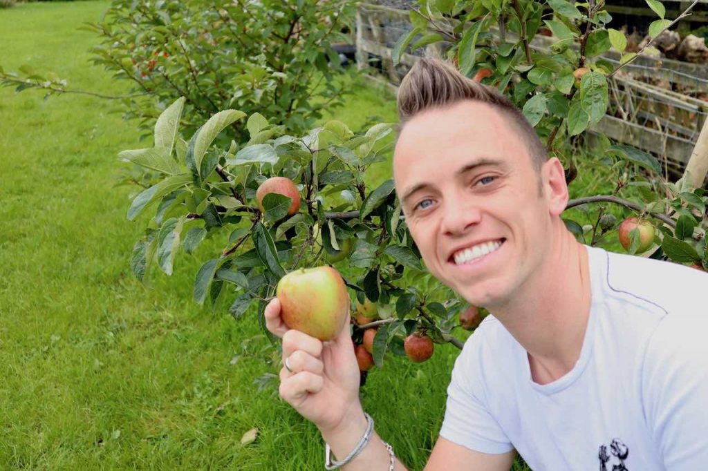 Garden Ninja smiling holding an apple