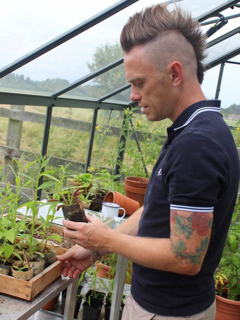 Garden Ninja holding a plastic free seedling