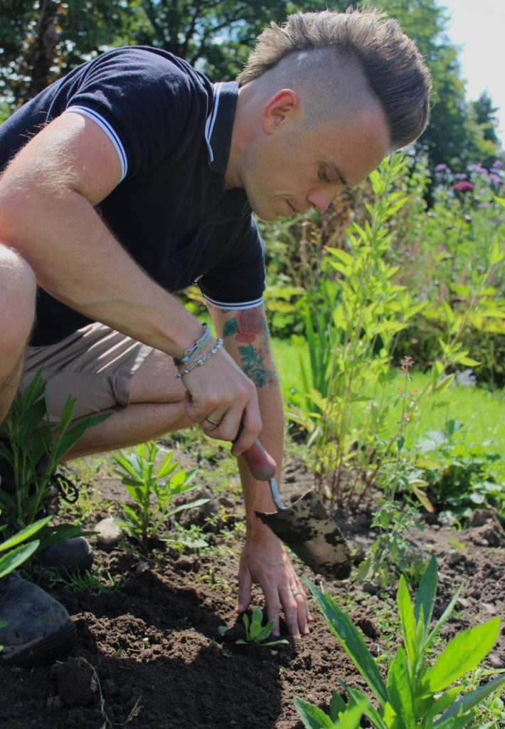 Lee Burkhill digging in a plant in his garden