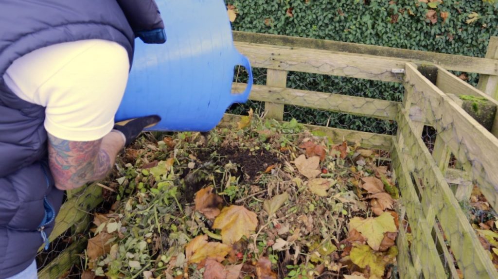 Lee Burkhill adding used compost to a compost bin